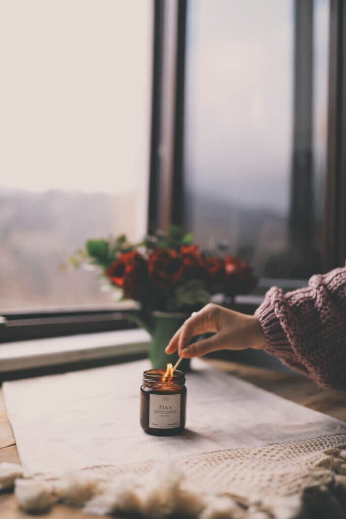 Lighting candle on a table with flowers