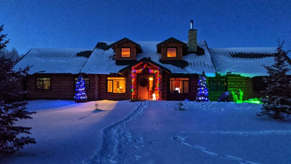 Log home with snow and Christmas Lights