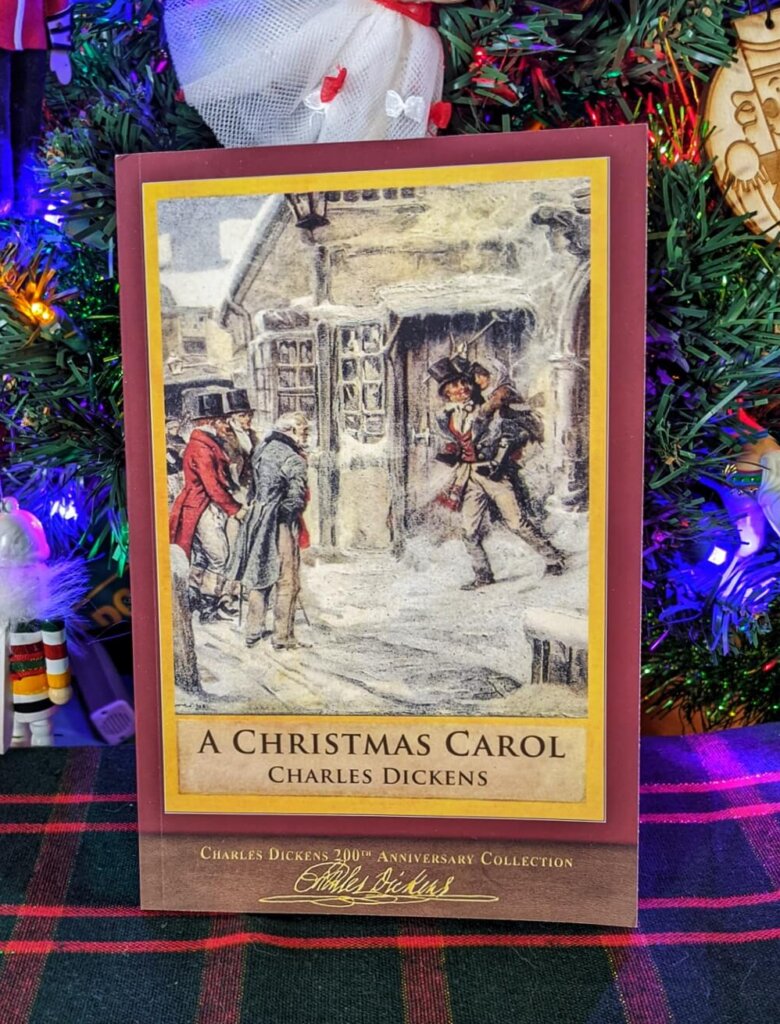 A Christmas Carol by Charles Dickens in front of the Christmas tree
