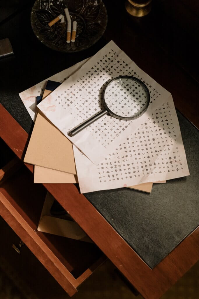 a magnifying glass over pages of cypher