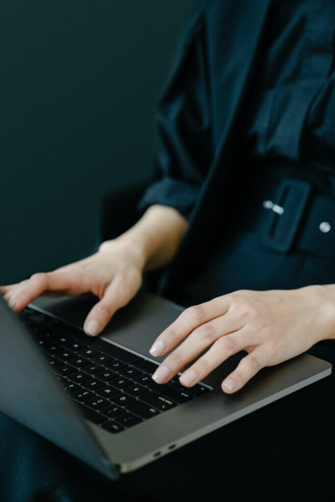 adult typing on laptop