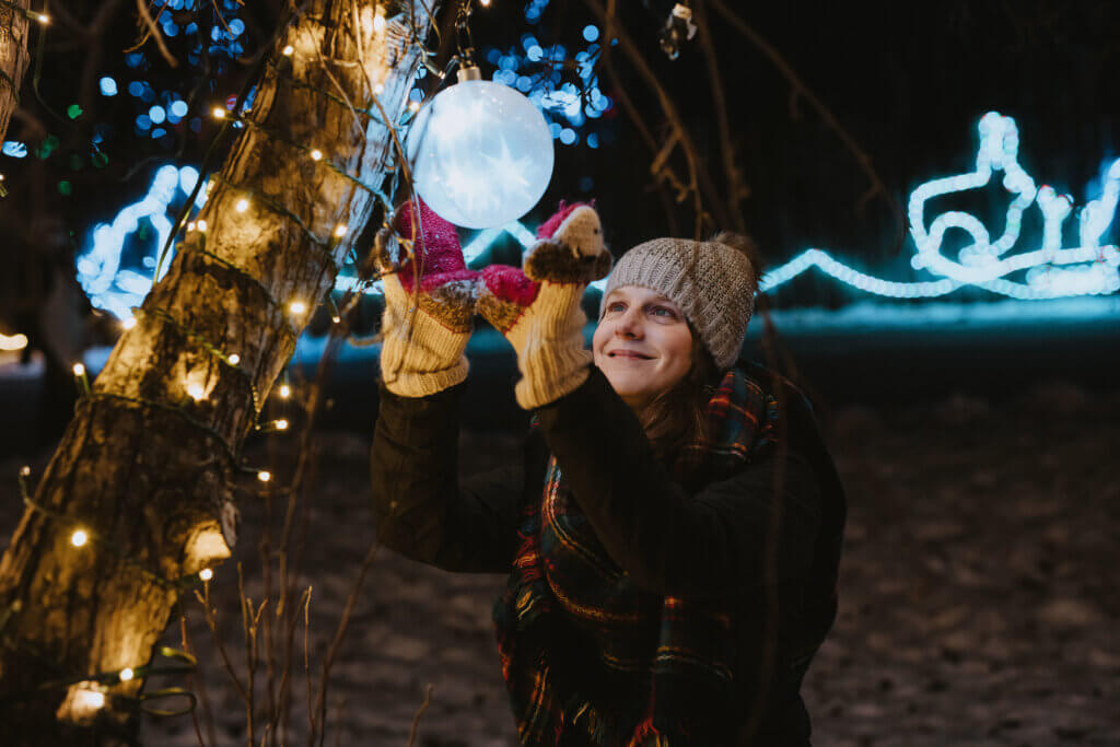 Woman standing under Christmas lights